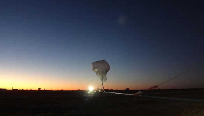 朝日を浴びながら放たれる大気球の写真